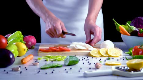 Chef-is-cutting-black-turnip-in-the-kitchen,-slicing-black-radish