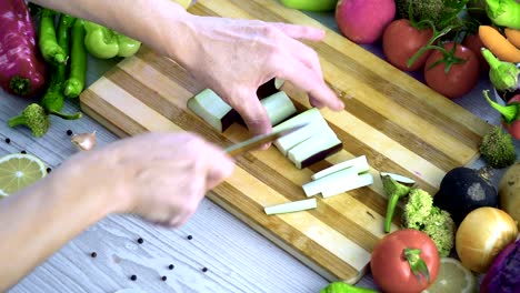 Man-is-cutting-vegetables-in-the-kitchen,-slicing-eggplant