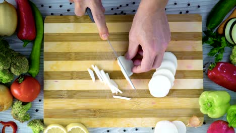 Chef-is-cutting-black-turnip-in-the-kitchen,-slicing-black-radish