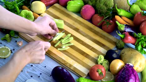 Man-is-cutting-vegetables-in-the-kitchen,-slicing-green-bell-pepper