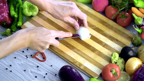 Man-is-cutting-vegetables-in-the-kitchen,-slicing-onion