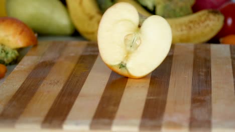 Man-is-cutting-vegetables-in-the-kitchen,-slicing-tomato-in-slow-motion