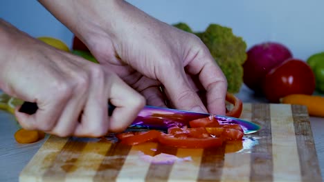 El-hombre-es-vegetales-de-corte-en-la-cocina,-cortar-el-tomate-en-cámara-lenta