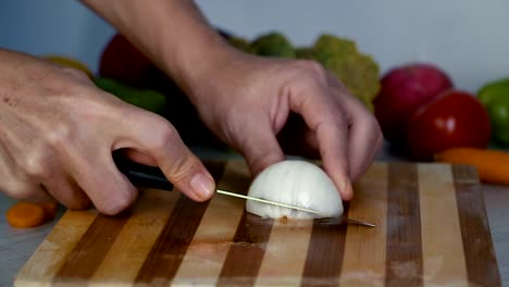 El-hombre-es-vegetales-de-corte-en-la-cocina,-cortar-el-tomate-en-cámara-lenta