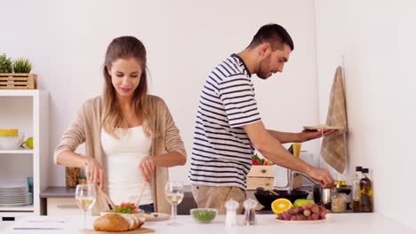 glückliches-Paar-Kochen-und-servieren-von-Speisen-zu-Hause