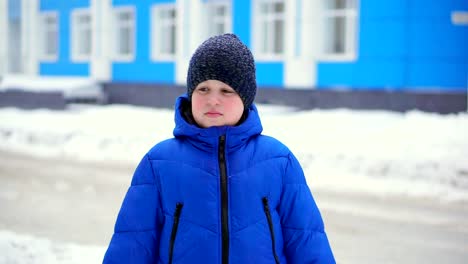 Boy-teenager-in-blue-down-jacket-lost-in-the-city.-He's-looks-around.