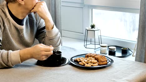 Sad-man-drinking-coffee-at-the-table.-Home-in-his-kitchen.-He-worries-because-of-his-problems.