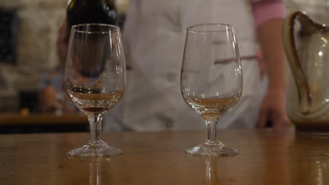 Wine-tasting-in-the-tasting-room.-Excursion-around-the-winery-of-Crimea.-Bakaly-stand-on-the-table.-Wine-is-poured-into-a-glass-dish.-Sommelier-extends-his-hand-to-his-glass.-SUNNY-VALLEY