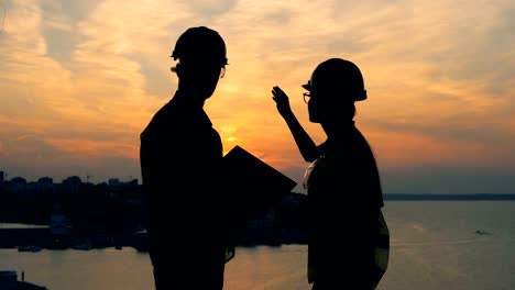 Ingenieros,-arquitectos-hablando-sobre-un-fondo-de-la-ciudad,-vista-lateral.