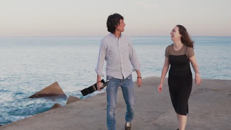 Beautiful-musician-couple-walk-walk-along-the-pier-by-the-sea