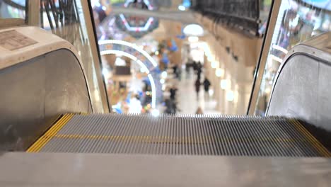 Escalator-in-the-mall-close-up.-In-the-background,-people-are-out-of-focus-for-shopping.