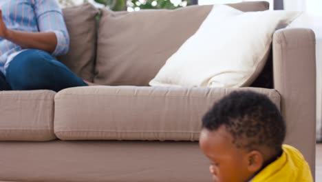 mother-using-tablet-pc-and-baby-playing-toy-blocks