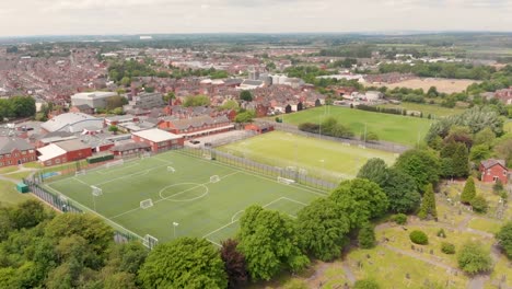 Aerial-footage-overlooking-the-British-town-of-Castleford-near-Wakefield-in-West-Yorkshire,-showing-rows-of-houses-and-fields-in-the-background,-taken-on-a-sunny-bright-summers-day.