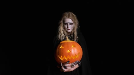 Halloween-Image-.Young-Witch-In-Black-Clothes-Holds-Pumpkin-In-Her-Hands.