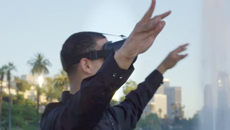 Young-african-american-man-wearing-VR-glasses-out-in-a-park