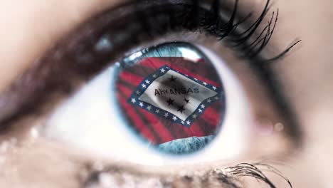 Mujer-ojo-azul-en-primer-plano-con-la-bandera-del-estado-de-Arkansas-en-iris,-estados-unidos-de-América-con-movimiento-de-viento.-concepto-de-vídeo