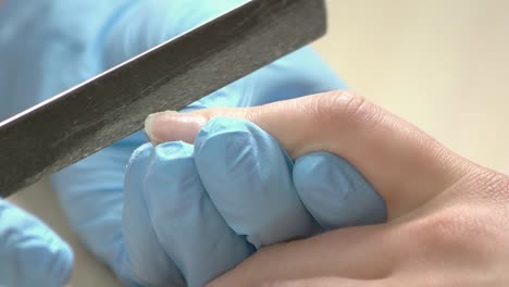 Manicurist-filing-nails,-slow-motion.