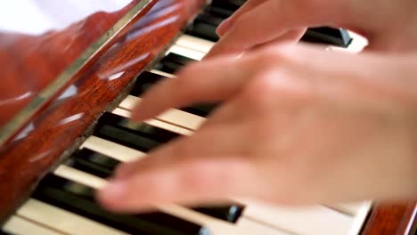 Female-fingers-playing-keys-on-retro-piano-keyboard.-Shallow-depth-of-field.-Focus-on-piano-keys