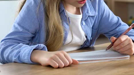 Mädchen-schreiben-Notebook-während-der-Schulstunde,-Hausaufgaben-Sport,-Bildung