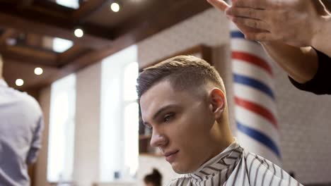 Professional-barber-makes-hairstyle-to-a-young-man