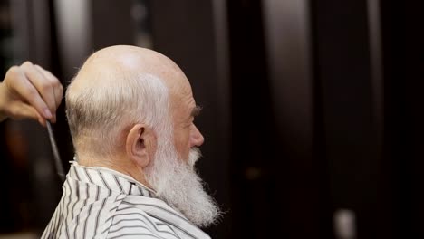 Estilista-rocía-el-cabello-del-hombre-senior-con-agua