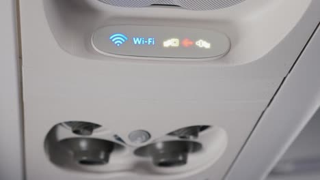 Panel-über-die-Köpfe-der-Passagiere-in-einem-Flugzeug-oder-Bus.-Lüftung-und-Wi-Fi-Abzeichen.-Komfort-und-Technik-auf-der-Straße