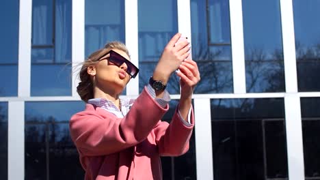 Selfie-frente-a-los-ultra-modernos-rascacielos.-Retrato-de-vista-lateral.-Oro-juvenil