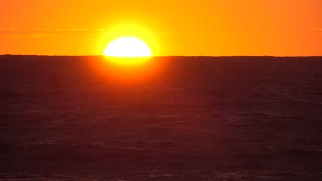 SLOW-MOTION-Bright-orange-Sonnenuntergang-hinter-dem-endlosen-blauen-Meer-an-einem-Sommertag