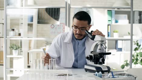 Focused-Black-Scientist-Using-Microscope