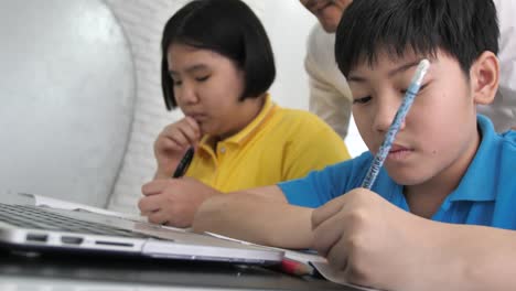 Tutor-room-children-in-class-learning-on-laptop-computer-with-teacher.-4K-Slow-motion-Asian-child-learning-with-teacher-at-home.