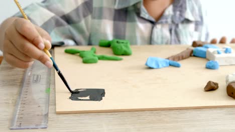 Child's-hands-playing-colorful-clay-and-paint-on-table.-Development-of-fine-motor-skills-of-fingers-and-creativity,-education