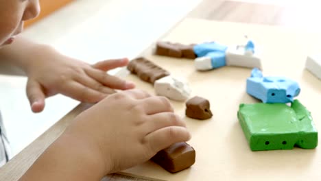 Child's-hands-playing-colorful-clay-on-table.-Development-of-fine-motor-skills-of-fingers-and-creativity,-education