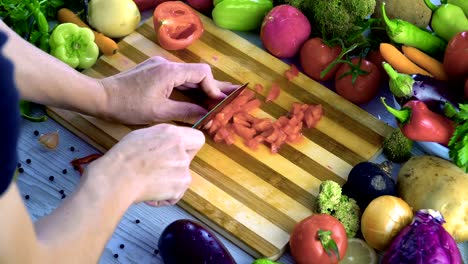 Man-is-cutting-vegetables-in-the-kitchen,-slicing-tomato