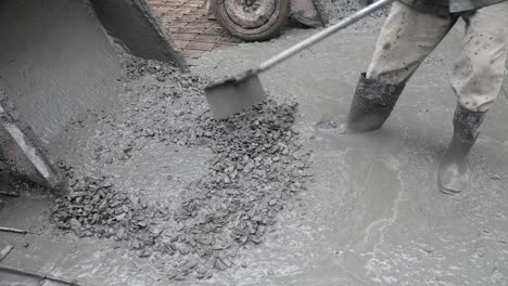 close-up-of-construction-workers-pouring-cement-on-a-rural-road