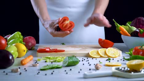 Man-is-cutting-vegetables-in-the-kitchen,-slicing-tomato-in-slow-motion