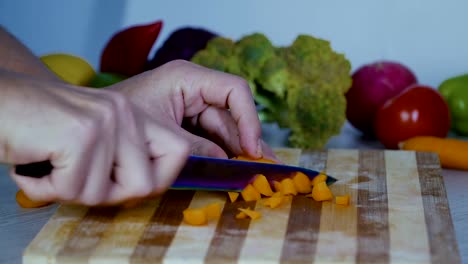 Man-is-cutting-vegetables-in-the-kitchen,-slicing-carrot