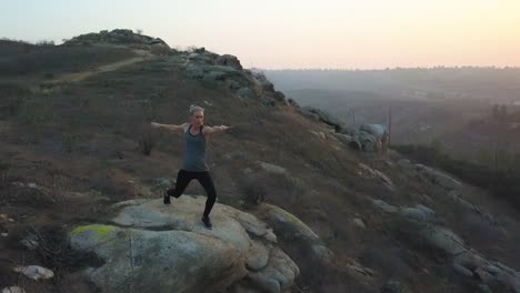 Aptitud-del-yoga-fuerte-mujer-hermosa-puesta-de-sol-naturaleza-aérea