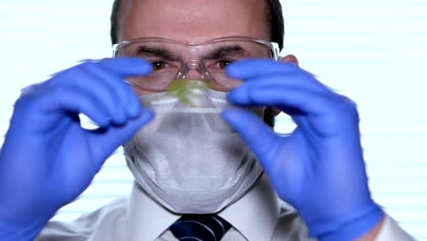 Biologist-examines-sample.-Science,-biology,-ecology.-Professional-scientist-wearing-protective-mask-working-with-herb-samples-in-his-laboratory.-Male-scientist-looking-at-plant-leaf-in-glass-slide.