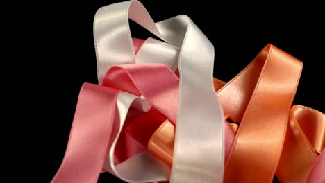 Satin-ribbon-on-a-black-background.-Slow-motion.