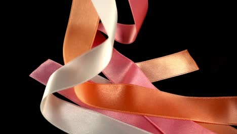 Satin-ribbon-on-a-black-background.-Slow-motion.