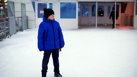 Junge-Teenager-in-blau-Daunenjacke-verloren-in-der-Stadt.-Er-ist-am-Bahnhof,-schaut-sich-um.