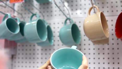 Someone-picks-a-big-ceramic-cup-in-the-supermarket.