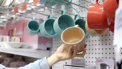 Jemand-nimmt-eine-große-Keramik-Tasse-im-Supermarkt.