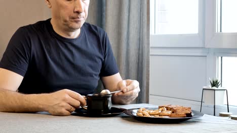 Man-drinking-coffee-in-the-morning-in-the-kitchen-at-home.