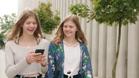 Young-Ladies-Using-a-Phone-in-Town