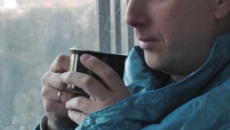 Man-drinking-coffee-in-the-morning-in-the-kitchen-at-home-close-up.-He-froze-and-wrapped-in-a-blanket.