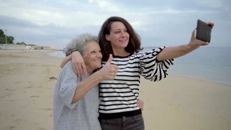 Schöne-Tochter-nehmen-Selfie-mit-Gesten-schon-ältere-Mutter