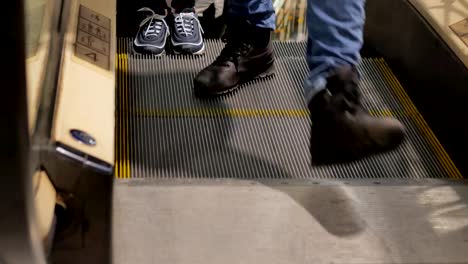 Escalator-in-the-mall.-Close-up-legs-of-people-who-buy-gifts-for-Christmas.