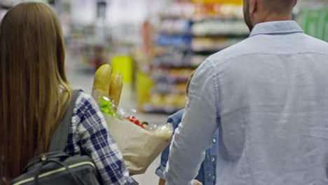 Hinterer-Blick-auf-Familie-durch-Supermarkt