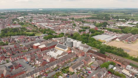 Aerial-footage-overlooking-the-British-town-of-Castleford-near-Wakefield-in-West-Yorkshire,-showing-rows-of-houses-and-fields-in-the-background,-taken-on-a-sunny-bright-summers-day.